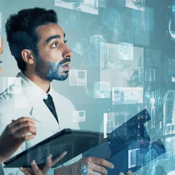 A male and female scientist reviewing digital data overlays—graphs, brain scans, and lab‐instrument visuals—on a transparent interface, symbolizing AI‑enabled data integration in modern labs