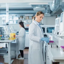 Lab technicians in a clinical laboratory processing blood samples using automated analyzers—illustrating essential lab ops for consistent clinical diagnostics.
