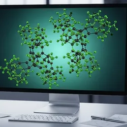 A computer monitor displays green molecular models, representing sustainable and eco-friendly chemical design. A potted plant on the desk reinforces the theme of green chemistry and environmental responsibility