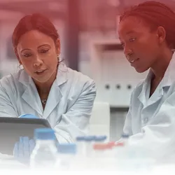 Two women scientists view a tablet