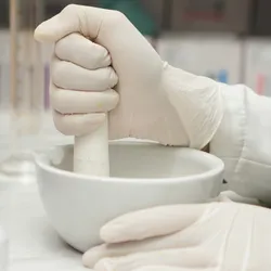 Scientist grinding solid sample in mortar and pestle, illustrating improvised laboratory sample preparation before validated milling