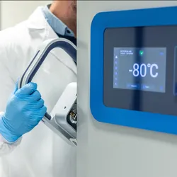 Technician monitoring AI-enhanced ultra-low temperature freezer in lab.