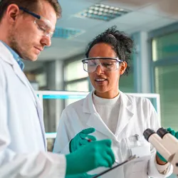 Two lab technicians reviewing peer feedback in a laboratory.