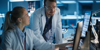 Two scientists examining data on computer in the lab.