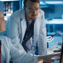 Two scientists examining data on computer in the lab.