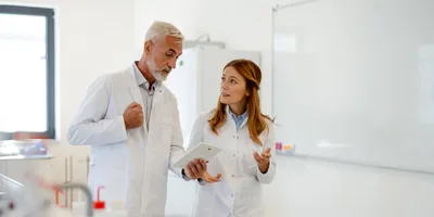 Senior lab leader coaching and advising a younger direct report 