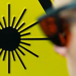 Person wearing laser protective eyewear near warning sign