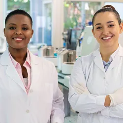 Radiation safety officer and lab manager in equipment-filled lab