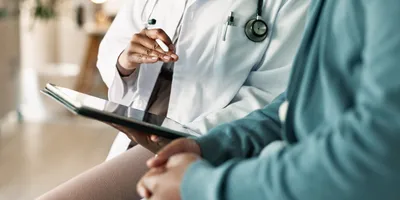 Doctor discussing faster diagnostic testing with a patient using a tablet.