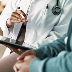 Doctor discussing faster diagnostic testing with a patient using a tablet.