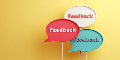 Three speech bubbles displaying the word 'Feedback' against a yellow background