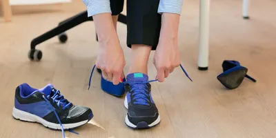 Individual preparing to walk in sneakers to reduce chronic lower back pain