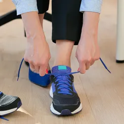 Individual preparing to walk in sneakers to reduce chronic lower back pain