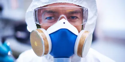 Lab worker with protective gear and respirator