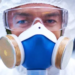 Lab worker with protective gear and respirator