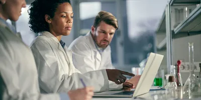 Technicians working together on AI literacy in laboratory settings