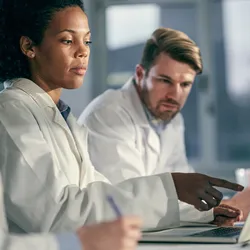 Technicians working together on AI literacy in laboratory settings