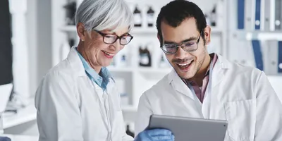 Two lab employees engaged and collaborating on a tablet