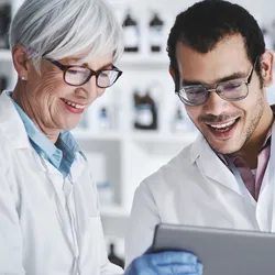 Two lab employees engaged and collaborating on a tablet