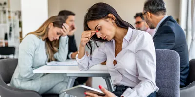 Stressed team meeting with one member showing concern