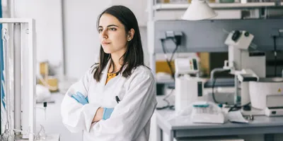 Employee in lab reflecting on job satisfaction and purpose
