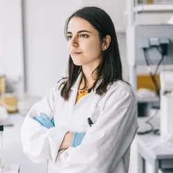Employee in lab reflecting on job satisfaction and purpose