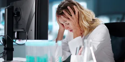 Stressed employee in laboratory showing signs of burnout