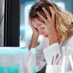 Stressed employee in laboratory showing signs of burnout