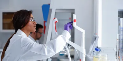 Woman in lab coat using a touch screen