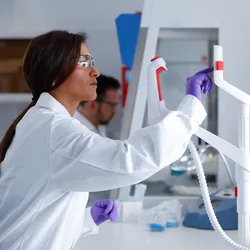 Woman in lab coat using a touch screen