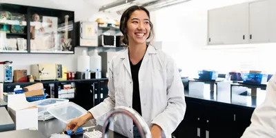 A lab technician smiling while working in a laboratory