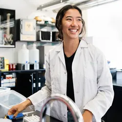 A lab technician smiling while working in a laboratory