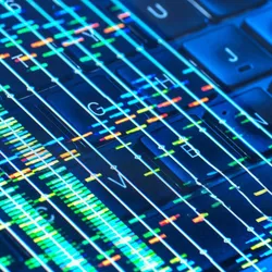 Colorful DNA sequencing data overlaid on a computer keyboard, symbolizing bioinformatics and turning biological data into actionable insights