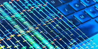Colorful DNA sequencing data overlaid on a computer keyboard, symbolizing bioinformatics and turning biological data into actionable insights