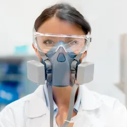 Laboratory worker wearing a respirator for safety.
