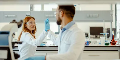 Two lab colleagues sharing a positive moment, fostering relationships.