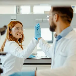 Two lab colleagues sharing a positive moment, fostering relationships.