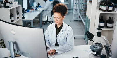 Scientist in a life science laboratory working on a computer 