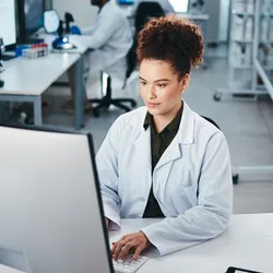 Scientist in a life science laboratory working on a computer 