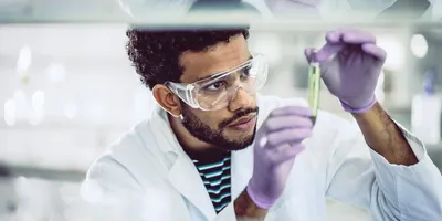 Scientist in lab gear assessing substance for TSCA chemical assessments