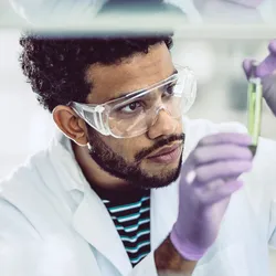 Scientist in lab gear assessing substance for TSCA chemical assessments