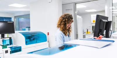 Lab professional reviewing automated syphilis testing workflow results at clinical analyzer workstation