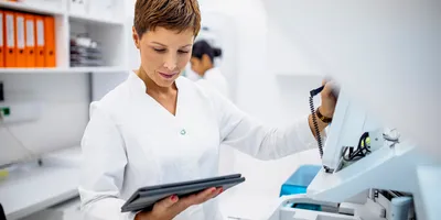 Lab manager reviewing lab equipment usage data on a tablet.