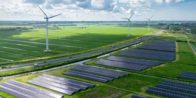 Aerial view of a renewable energy site with solar panels and wind turbines