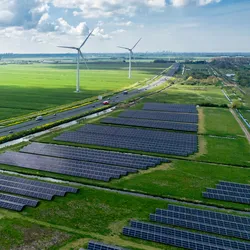 Aerial view of a renewable energy site with solar panels and wind turbines
