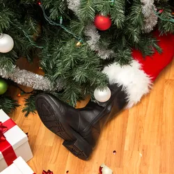 Santa's legs beneath a Christmas tree with gifts, highlighting how holiday movie mishaps relate to lab safety