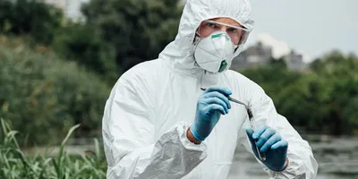 Researcher in protective gear conducting environmental testing