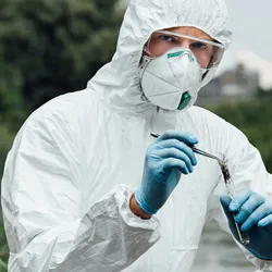 Researcher in protective gear conducting environmental testing