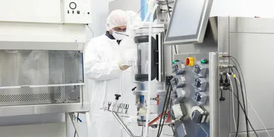 Technician in a cleanroom at a bioprocess design center