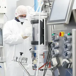 Technician in a cleanroom at a bioprocess design center